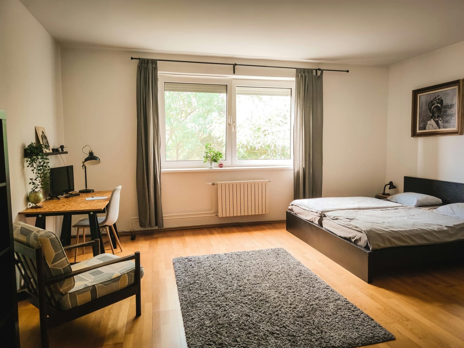Bright bedroom with a double bed, a desk and an armchair